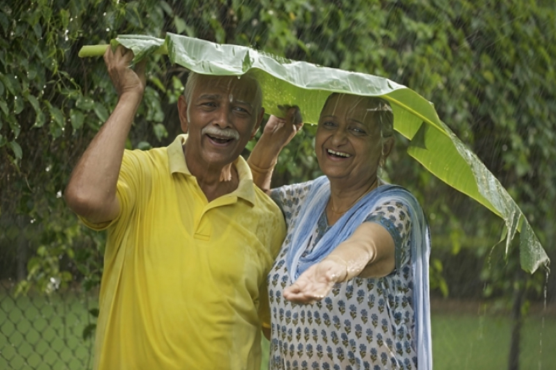 A happy senior couple in the rain.